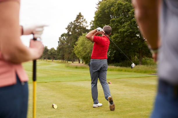 golf professional demonstrating tee shot to group of golfers during lesson - golf playing teeing off men photos et images de collection