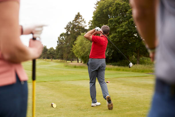 professionista del golf che dimostra tee shot a un gruppo di golfisti durante le lezioni - golf playing teeing off men foto e immagini stock