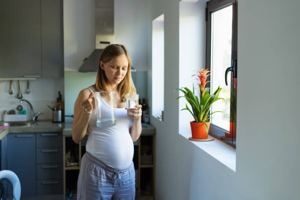 istock Pensive expectant mother drinking water in kitchen 1197868809