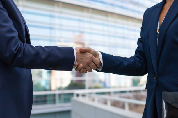 istock Business ladies in formal suits shaking hands 1197870206