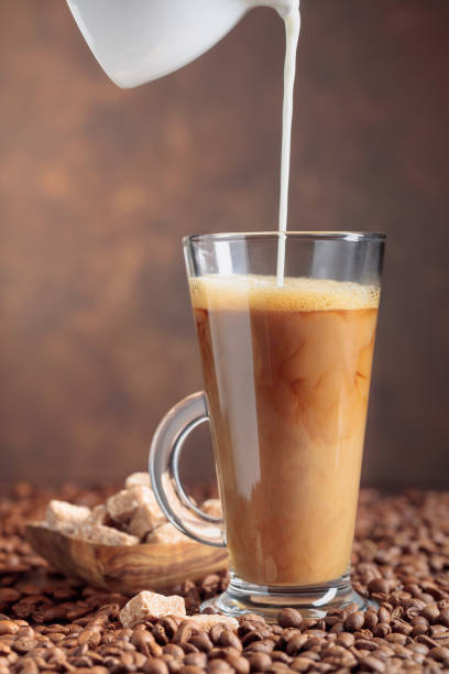 istock Coffee with cream and brown sugar on a table with coffee beans. 1197872182