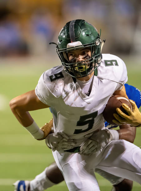 young football player in action during a game - football player american football sports team teamwork imagens e fotografias de stock