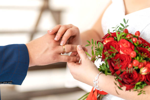 die braut legt einen ehering auf den finger des bräutigams. hochzeit details. - cluster verlobungsringe stock-fotos und bilder