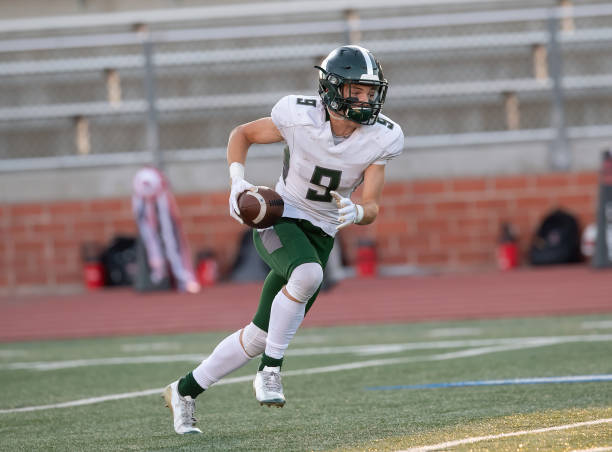 young football player in action during a game - football player american football sports team teamwork imagens e fotografias de stock