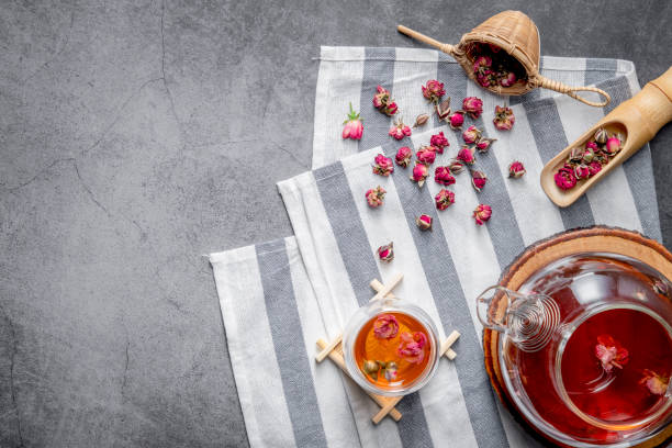 istock tea made from tea rose petals in a glass bowl on drak black rustic background, Concept tea time. 1197882890