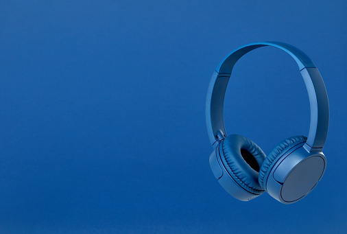 Blue wireless headphones on blue background