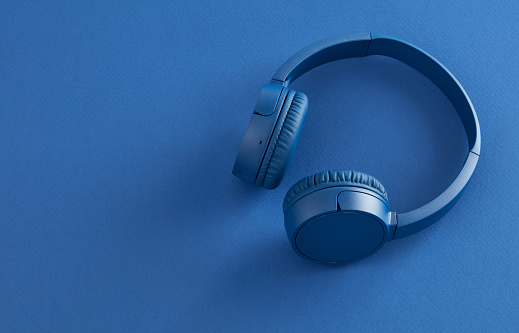 Blue wireless headphones on blue background