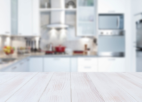 Empty kitchen countertop with defocused modern kitchen background. Highly suitable for product montage