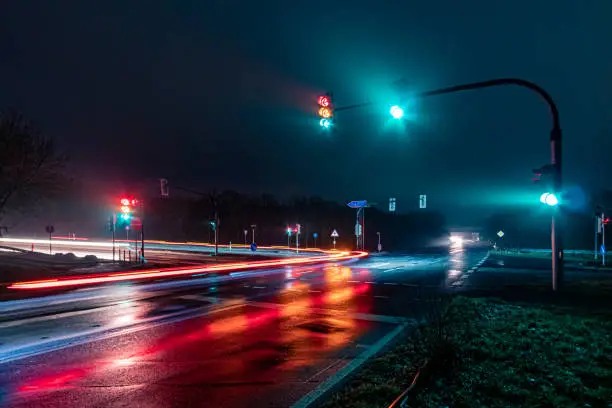 Photo of traffic lights and wet road at night