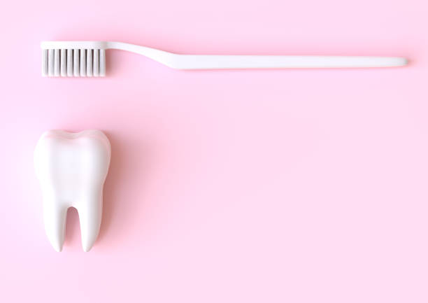 istock Toothbrush and white tooth on a pink background 1197890881