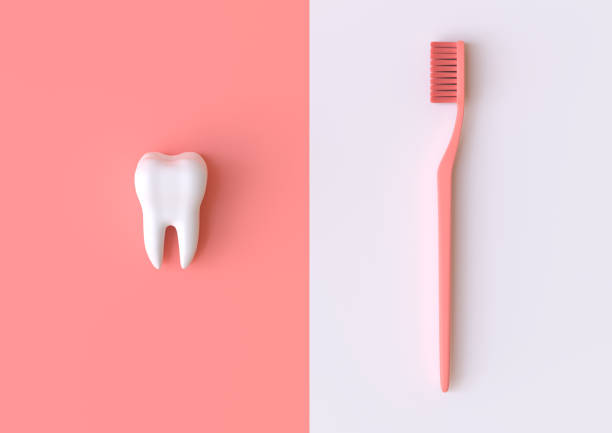 istock Toothbrush and white tooth on a coral background 1197890993