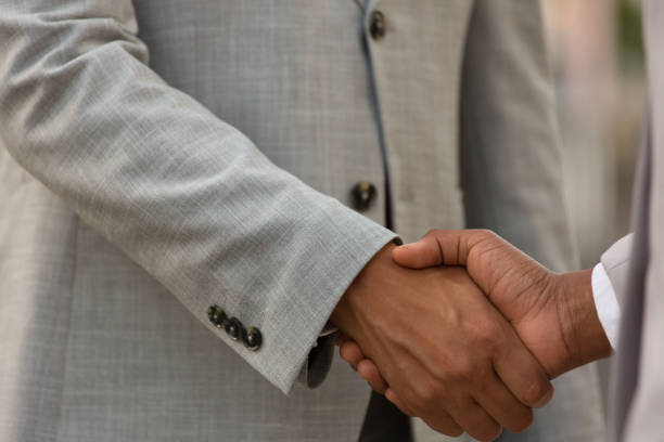istock Business partners in office suits shaking hands 1197891243