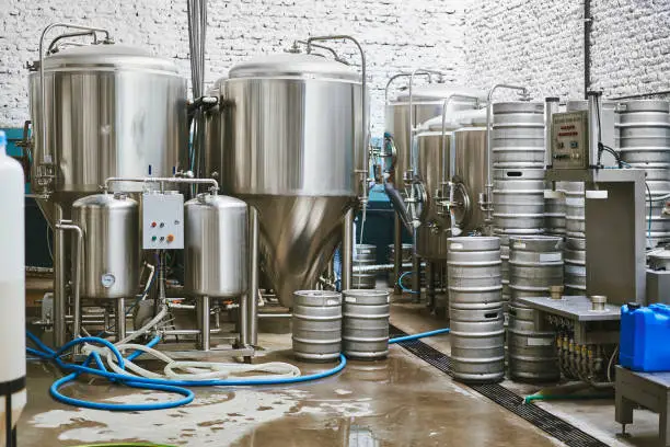 Stainless steel vats, kegs, and all manner of equipment required for creation of craft beer in Buenos Aires brewery.