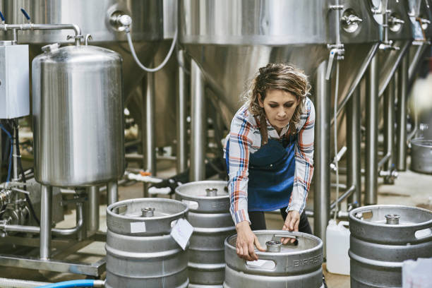 Hispanic Female Brewery Worker Lifting Beer Keg