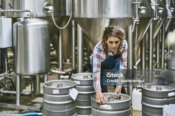 Hispanic Female Brewery Worker Lifting Beer Keg Stock Photo - Download Image Now - Brewery, Keg, Craft Beer
