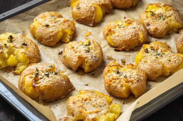 crispy smashed potatoes roasted with garlic and parmesan. - smashed potatoes imagens e fotografias de stock