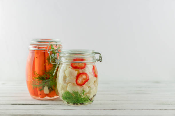 istock two glass jars of fermented cauliflower, carrots. vegetables on a light background. fermentation is a source of probiotic 1197894757
