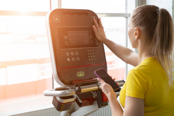 istock Woman adjusting settings on training machine in gym 1197897906