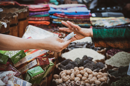 A customer hands money to a vendor at a market in Cairo, Egypt