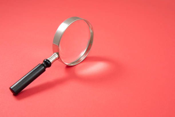 istock Magnifying Glass on Red Background 1197899076
