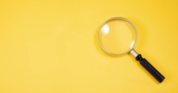 istock Close up Magnifying Glass on Yellow Background 1197899180
