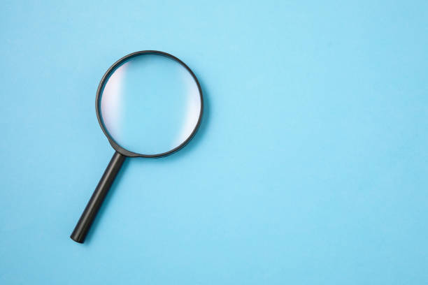 istock Magnifying Glass on Blue Background 1197899277