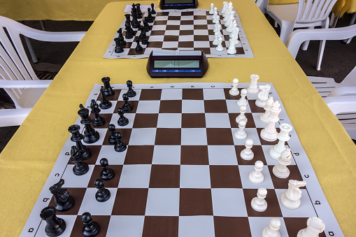 Chess tournament. Hall with prepared tables on which chess boards with clock are laid out, before the start of the competition. Learning concept. Education.