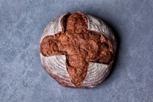 handwerker laib von traditionellen hausgemachten pumpernickel sauerteig boule brot mit kruste auf einem holzbrett - pumpernickel stock-fotos und bilder