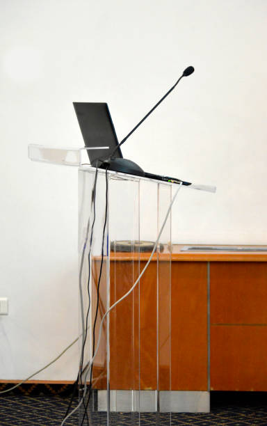 istock Laptop and microphone on the modern, transparent, plastic pulpit 1197902396