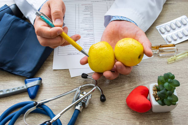 arzt ernährungsberater während der beratung in der hand gehalten und zeigt patienten gelben apfel. beratung und erklärung der verwendung von apfel in lebensmitteln und ernährung, gesundheitliche vorteile, wirkung auf körper und organe, immun - dieting weight scale doctor patient stock-fotos und bilder