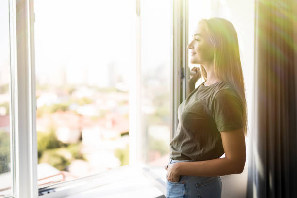istock Happy woman open plastic windows for fresh air indoor 1197904078