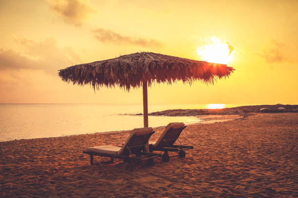 two sun chairs at the beach at sunset at the sultanate of oman.