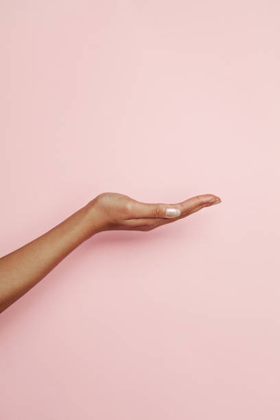 empty woman hand on pink background. woman hand presenting - hands open imagens e fotografias de stock