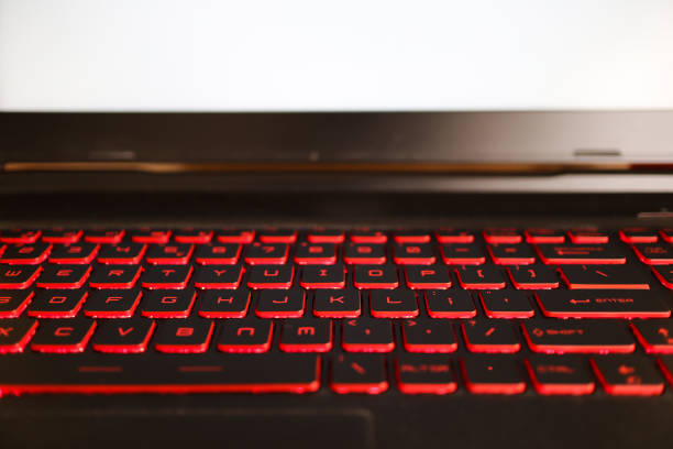 istock red glowing back lit keyboard of a gaming laptop with white mock up screen. 1197914907