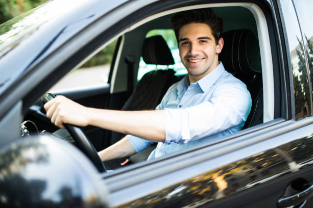 istock Concentrating on the road. Young handsome man looking straight while driving a car 1197915158