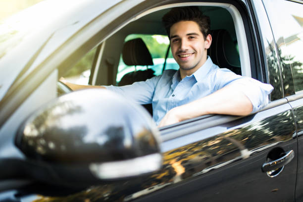 istock Concentrating on the road. Young handsome man looking straight while driving a car 1197915817