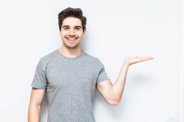 istock Young man showing something with his hand isolated on white background 1197917695
