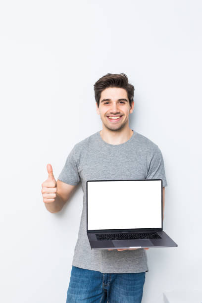 istock Young man presenting laptop on white screen isolated on white background 1197917760