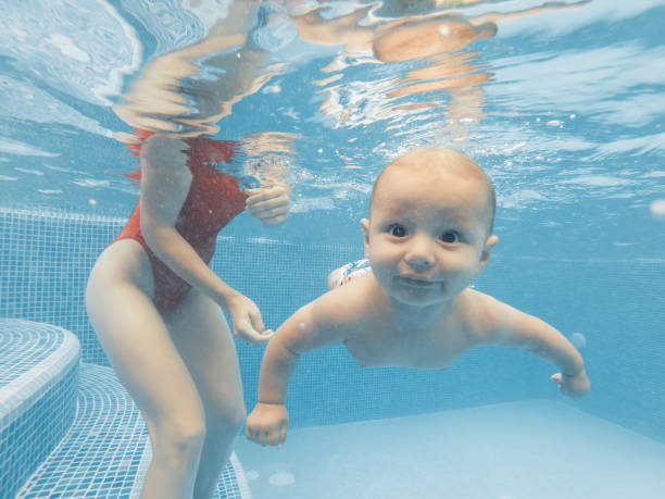 lycklig mor och son i poolen - baby swim under water bildbanksfoton och bilder