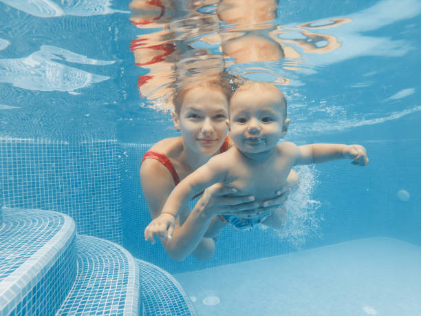 istock Happy mother and son in the pool 1197919289