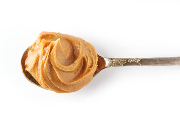 istock spoon of peanut butter isolated on white background, top view 1197919530