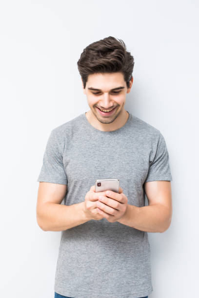istock Handsome young man using his smartphone isolated on white background 1197920554