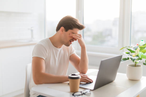 istock Frustrated with problems young man working on laptop computer at home 1197920787