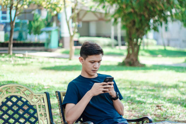 istock Asian Man Using Smart Phone At park 1197921456
