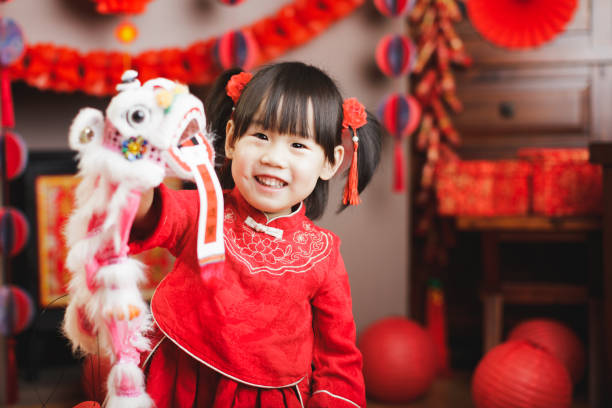chinesische baby-mädchen mit traditionellen verkleidung feiern chinesisches neues jahr - chinesisches neujahr fotos stock-fotos und bilder