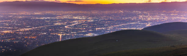 Panoramic night view of San Jose, Silicon Valley; the downtown area buildings visible on the right; green hills partially blocking the view; San Francisco Bay Area, California Panoramic night view of San Jose, Silicon Valley; the downtown area buildings visible on the right; green hills partially blocking the view; San Francisco Bay Area, California san francisco bay stock pictures, royalty-free photos & images