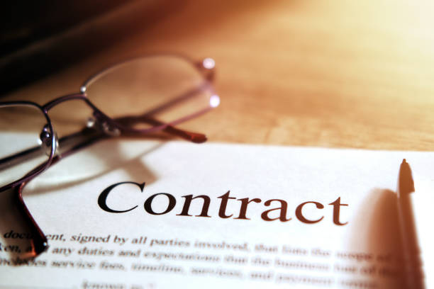 istock Contract sheet with glasses and a pen on a wooden background 1197931020
