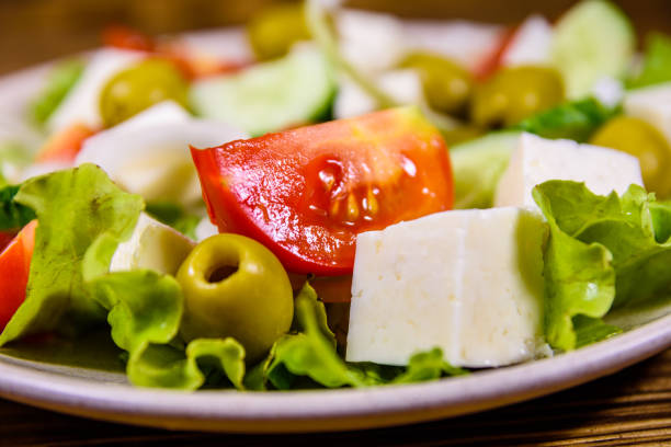Ceramic plate with greek salad on rustic wooden table