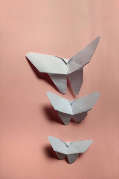 istock White paper butterflies on pink background. decorative concept 1197932344