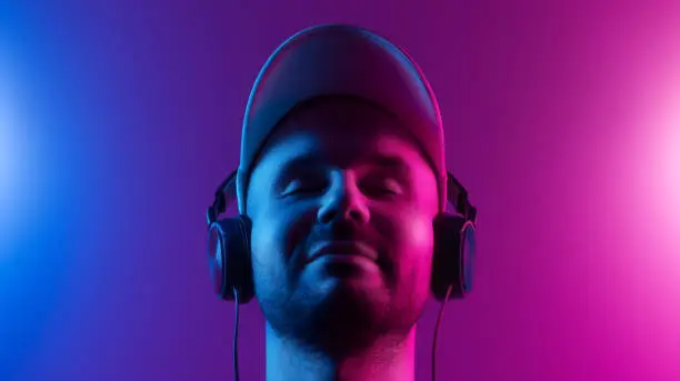 Photo of A man with closed eyes enjoys music. Dual color theme